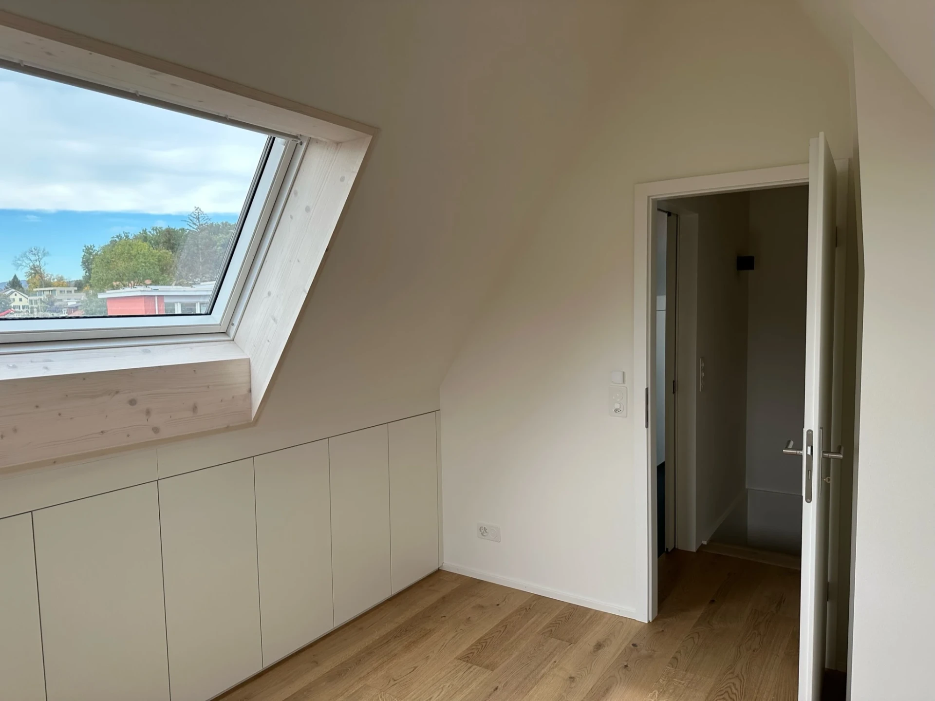 Heller Dachraum mit offener Tür und Dachfenster