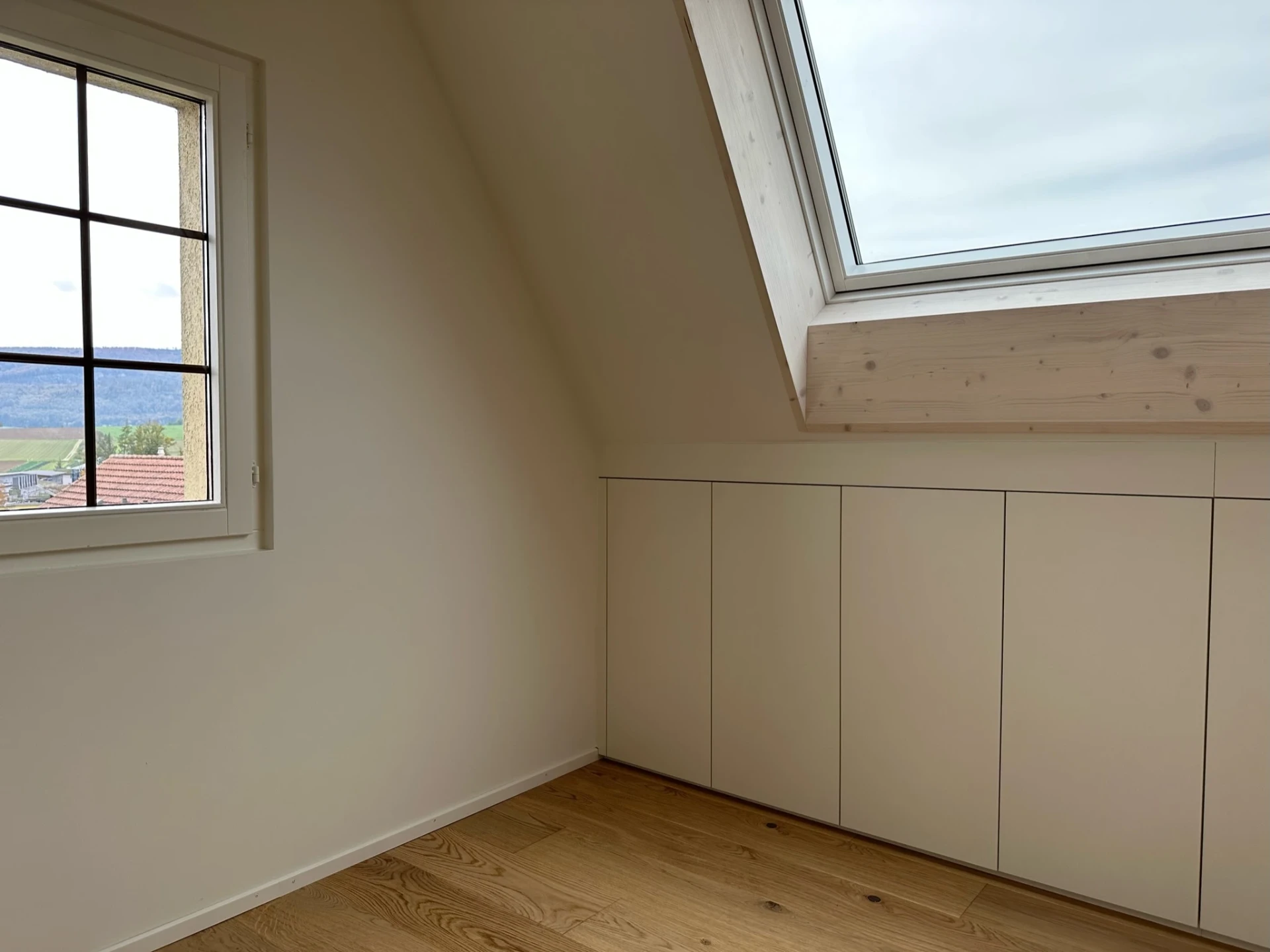 Dachraum mit Fenster und hellen Einbauschränken